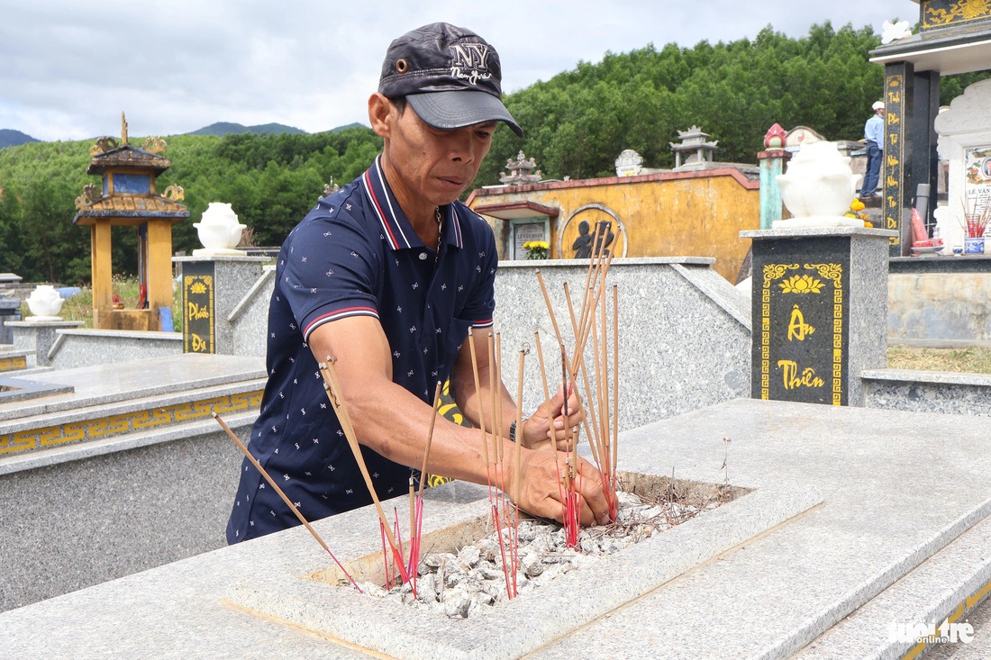 Người dân thắp nhang ở mộ - Ảnh: LÊ TRUNG