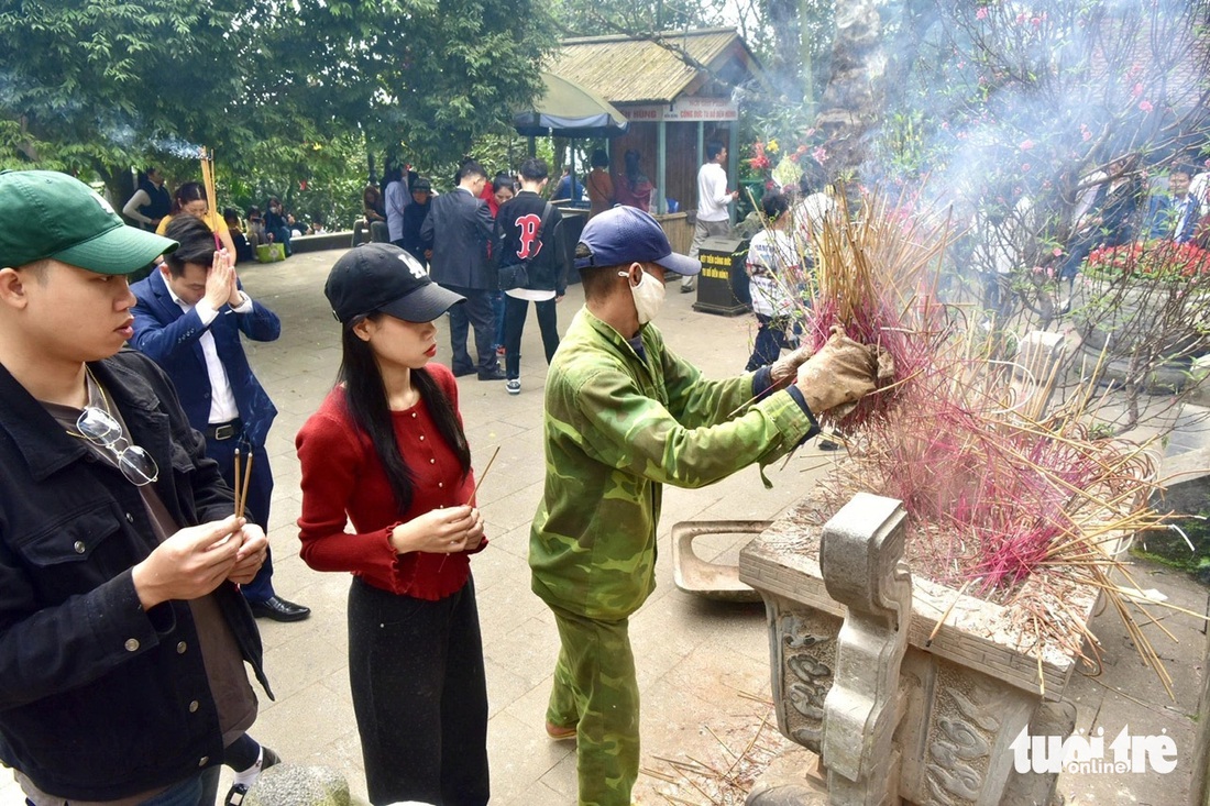 Nhân viên thu gom nhang (hương) để tránh phỏng tay và tránh ô nhiễm không khí - Ảnh: T.T.D.