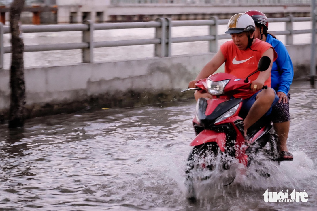 Càng về tối nước triều càng dâng cao, đường Trần Xuân Soạn đã ngập lên xấp xỉ đầu gối