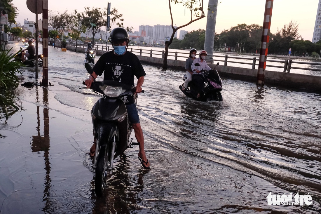 Ông Năm vừa đi từ quận 4 sang quận 7 để mua đồ thì gặp cảnh triều cường trên đường Trần Xuân Soạn. Ông nghĩ vẫn có thể chạy qua được, nào ngờ xe ông chết máy giữa đường. 