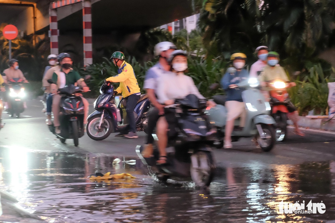 Dưới chân cầu Tân Thuận 2 (quận 7) hướng rẽ vào Trần Xuân Soạn, nhiều người thấy cảnh nước ngập liền quay đầu xe để đi đường khác