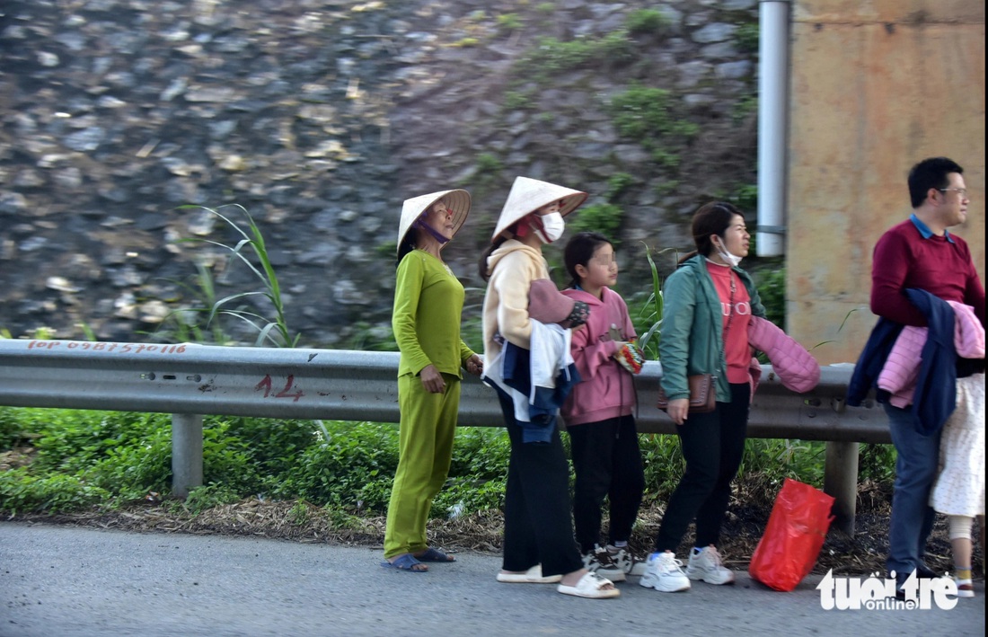 Những người dân leo vô cao tốc Nội Bài - Lào Cai hướng về Hà Nội để đón xe khách. Ảnh chụp tại địa phận xã Văn Quán, huyện Lập Thạch, Vĩnh Phúc ngày 11-2