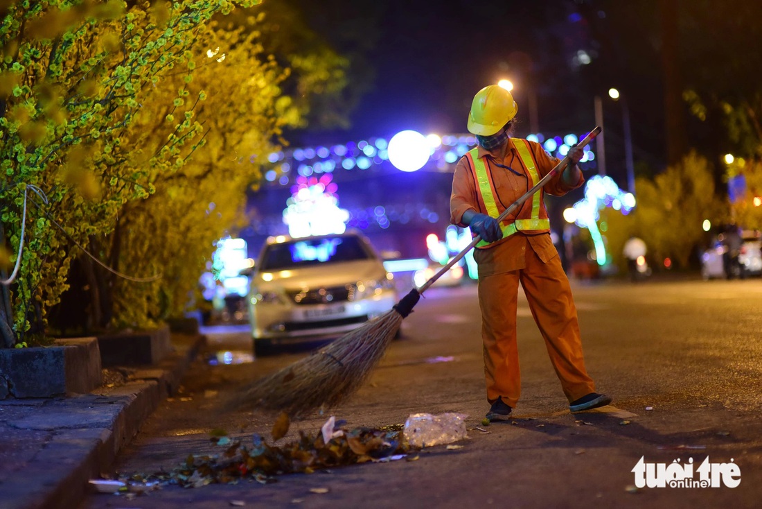 Người công nhân môi trường mong muốn được về nhà sớm hơn vào đêm giao thừa. Ý thức người dân khi tham gia lễ hội, bớt xả rác sẽ biến điều này thành hiện thực - Ảnh: QUANG ĐỊNH