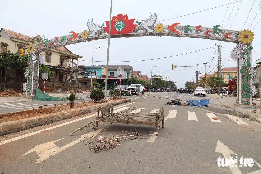 Cái giường gỗ cũ kỹ, cành cây, bạt rách, thanh sắt gỉ... được đưa ra rào chắn tuyến đường tiền tỉ - Ảnh: HOÀNG TÁO