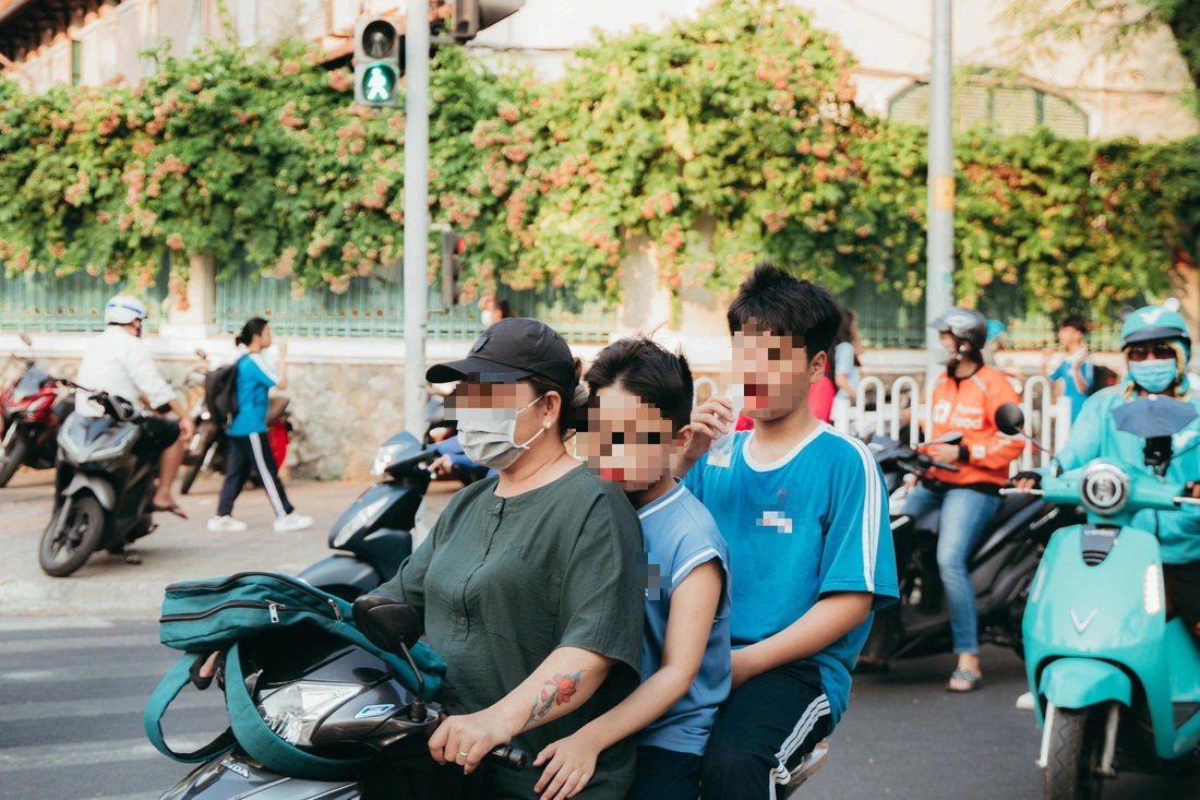 Hình ảnh trái ngược giữa hai cặp anh em được phụ huynh trang bị mũ bảo hiểm và không trang bị mũ bảo hiểm - Ảnh: THANH HIỆP