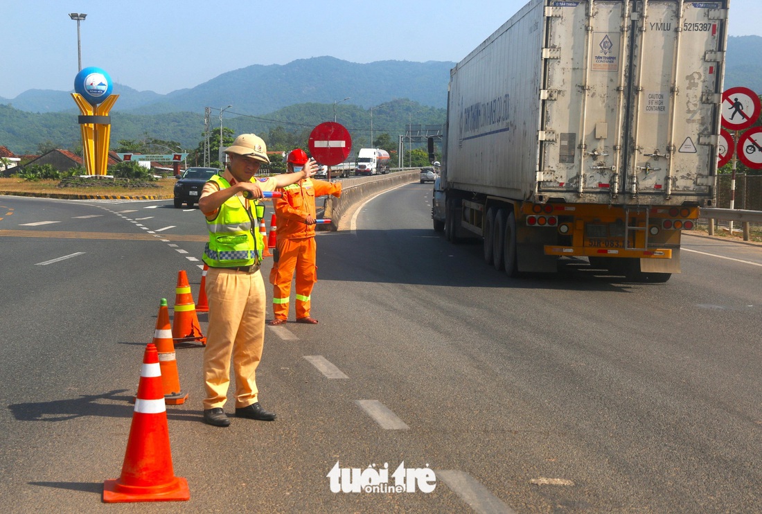 Lực lượng cảnh sát giao thông tỉnh Phú Yên phân luồng cho xe chuyển sang hầm đường bộ đèo Cả để giảm áp lực mặt đường bộ xuống hầm đường sắt Bãi Gió - Ảnh: NGUYỄN HOÀNG