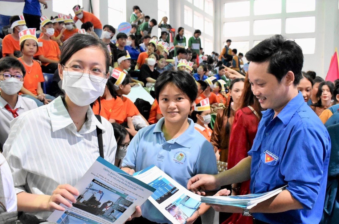 Công nhân điện lực tham gia phát tờ rơi tuyên truyền tiết kiệm điện tại một trường hợc ở miền Trung - Ảnh: EVNCPC cung cấp