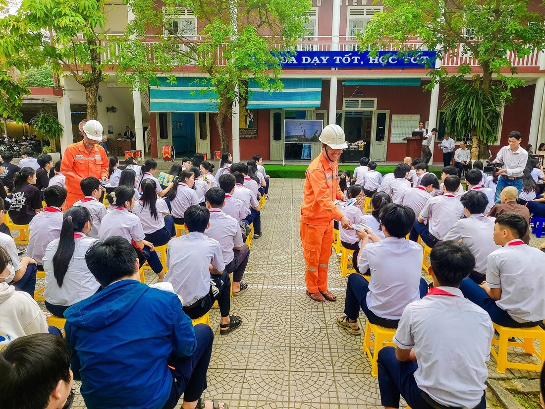 Công nhân điện lực tham gia phát tờ rơi tuyên truyền tiết kiệm điện tại một trường hợc ở miền Trung - Ảnh: EVNCPC cung cấp