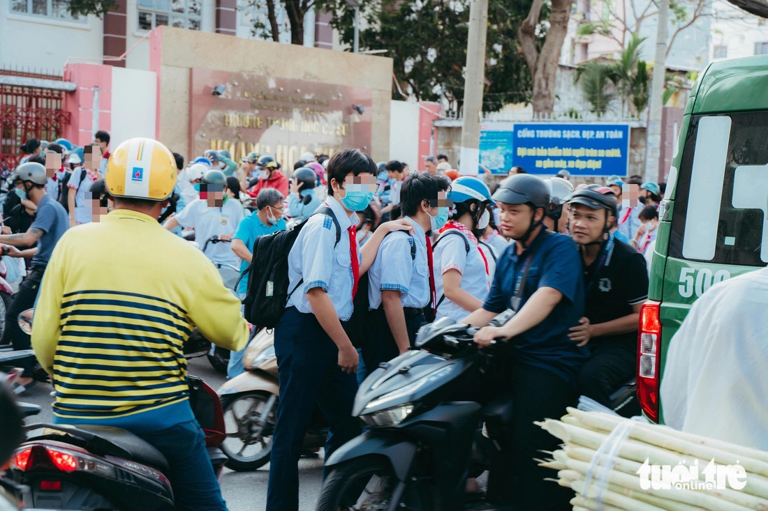 Học sinh muốn sang đường phải tự len lỏi qua làn xe đông đúc - Ảnh: THANH HIỆP