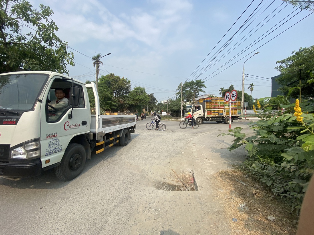 Học sinh tới trường phải đi ngang trước đầu xe tải vào khu dân cư né thu phí - Ảnh: B.D.