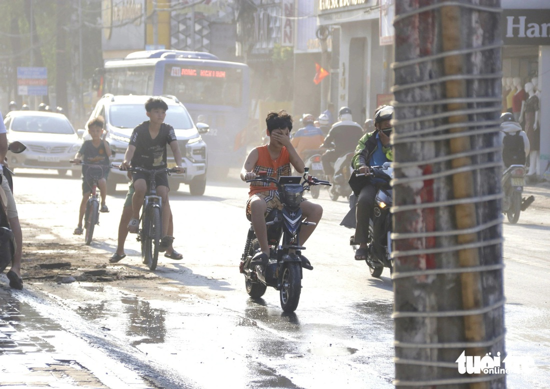 Người đi đường ngán ngẩm vì bụi bay mù mịt - Ảnh: TIẾN QUỐC