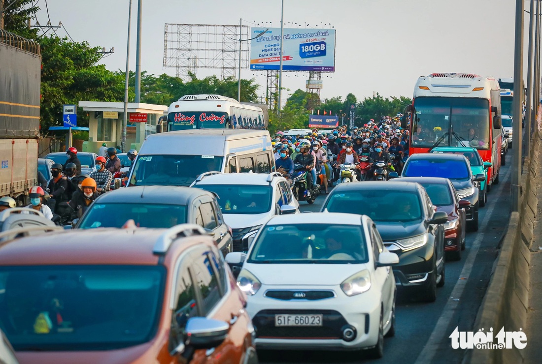 Có một vài lúc, xe cộ đi lại khá chậm ở dốc cầu Nguyễn Văn Linh (huyện Bình Chánh) - Ảnh: LÊ PHAN