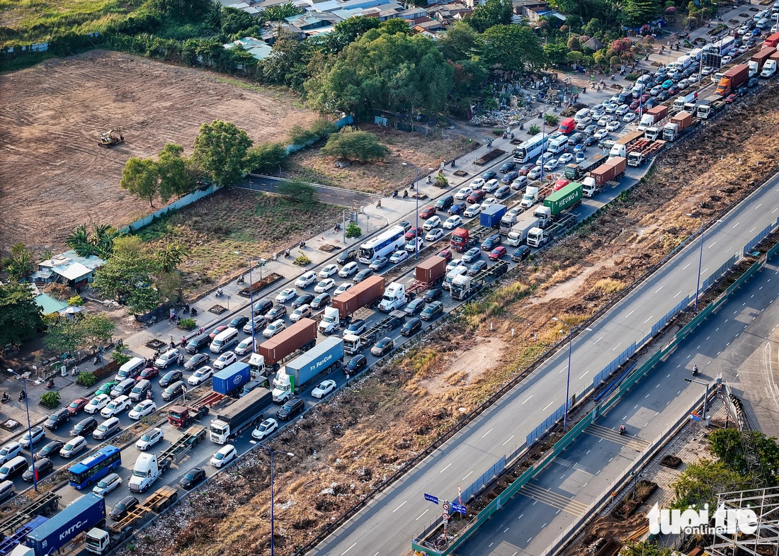 Do xe cộ ken đặc trên đường Mai Chí Thọ, nên nhiều xe máy chọn cách chạy lên vỉa hè - Ảnh: CHÂU TUẤN