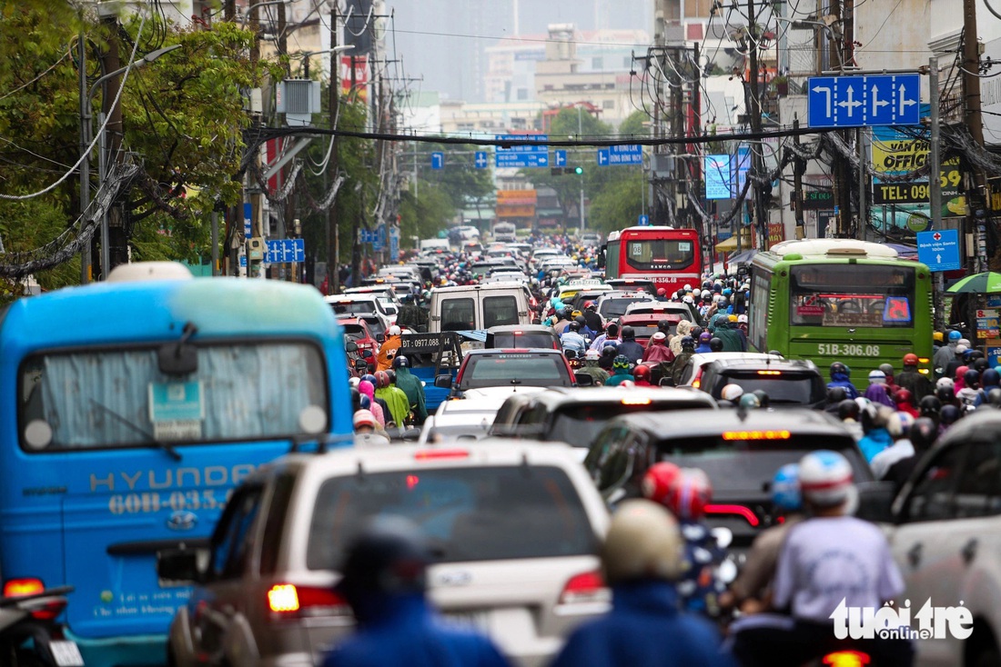 Trong khi đó, dòng xe từ phía đông TP.HCM vào trung tâm ùn tắc ở giao lộ Bạch Đằng - Đinh Bộ Lĩnh trong cơn mưa sáng 20-5 - Ảnh: PHƯƠNG QUYÊN