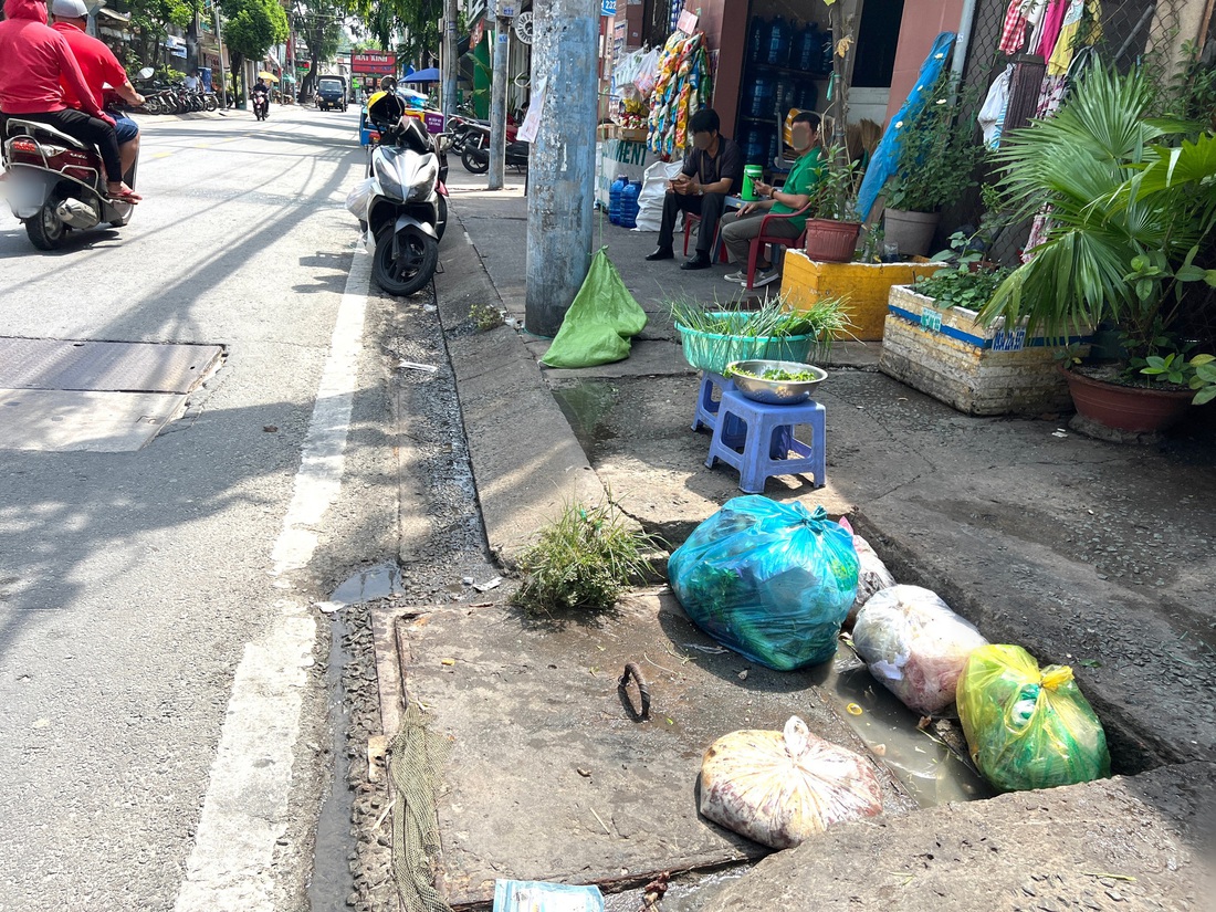 Rác không bỏ vào thùng, mà để ngay miệng cống thoát nước đường Linh Đông, TP Thủ Đức - Ảnh: XUÂN ĐOÀN