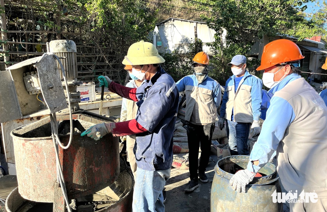 Công nhân tiến hành trộn bê tông để bơm vào vị trí sạt lở trên đỉnh hầm đường sắt Chí Thạnh - Ảnh: NGUYỄN HOÀNG