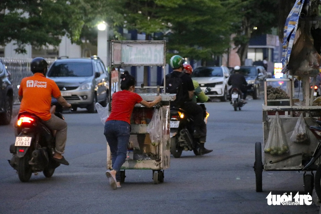 Hàng rong đẩy xe chạy trốn khi được đồng đội báo có Phòng quản lý đô thị tới tuần tra trên đường Võ Oanh (quận Bình Thạnh) - Ảnh: TIẾN QUỐC