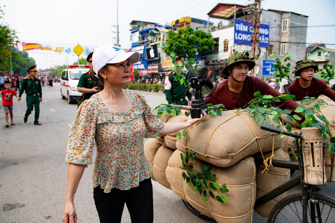 Do trời oi bức, một người dân mang theo quạt 