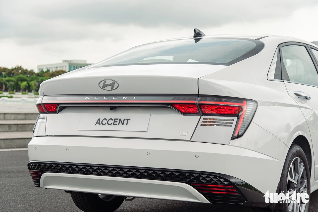 Chi tiết Hyundai Accent 2024 giá cao nhất 569 triệu đồng: Lột xác toàn diện trước Vios, City- Ảnh 7. Hyundai Accent 2024 có phần đuôi hơi vuốt xuống kiểu Fastback, trông trở nên thể thao và trẻ trung hơn. Cụm đèn hậu LED kéo dài sang hai bên dạng chữ H. Cản sau có 4 cảm biến và camera lùi. Cốp xe vẫn chỉ đóng/mở cơ, nhưng tích hợp tính năng mở cốp rảnh tay (Smart trunk) rất hữu dụng khi xách đồ.