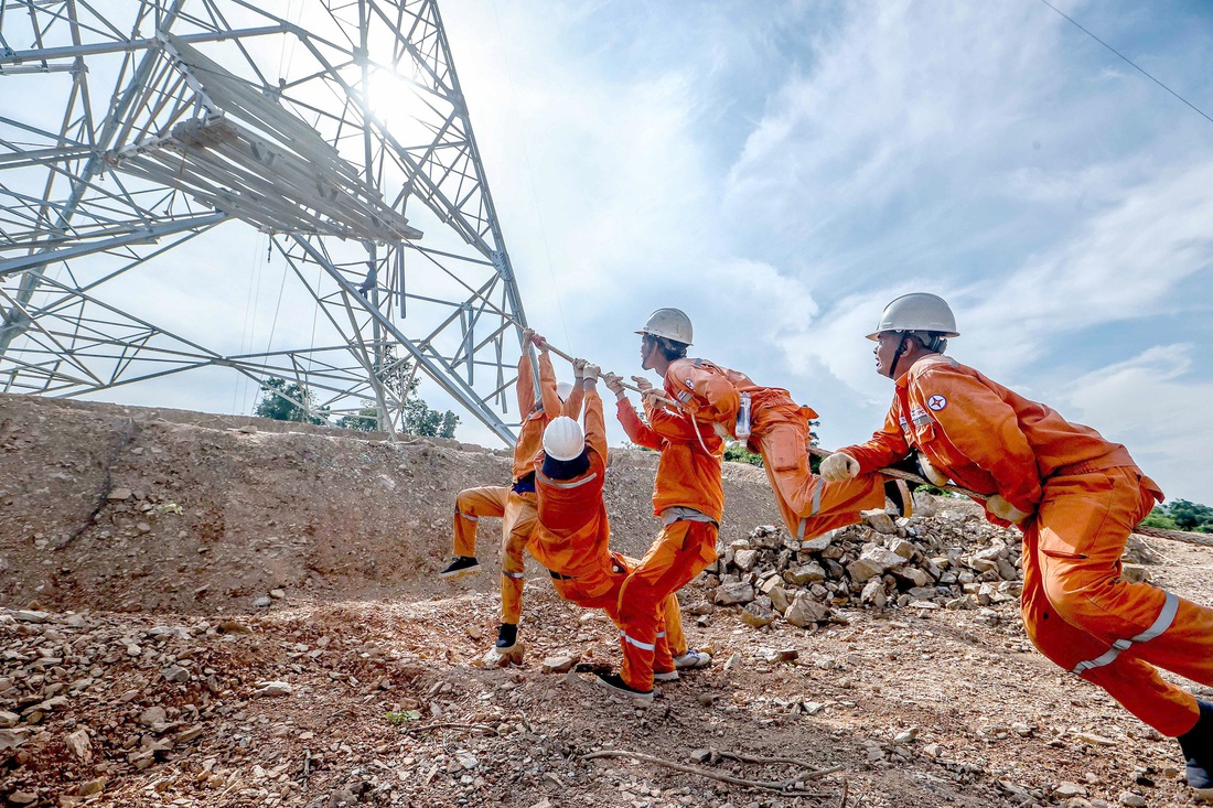 Công nhân nỗ lực kéo thiết bị lắp ghép tại cột 42 thuộc địa phận huyện Nghi Sơn (Thanh Hóa) - Ảnh: NGUYỄN KHÁNH