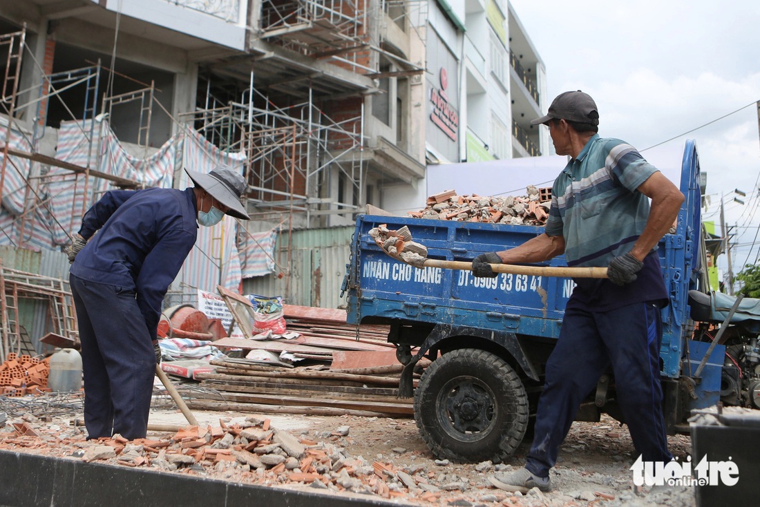 Công nhân thu dọn xà bần sau khi phá dỡ nhà ở số 648 Cách Mạng Tháng 8