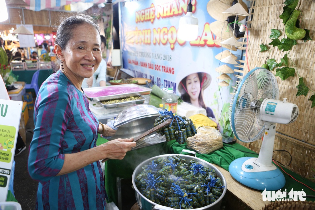 Bếp bánh ở gian hàng của nghệ nhân Huỳnh Ngọc Lan liên tục đỏ lửa để cho ra đời những chiếc bánh thơm ngon phục vụ người dân - Ảnh: PHƯƠNG QUYÊN