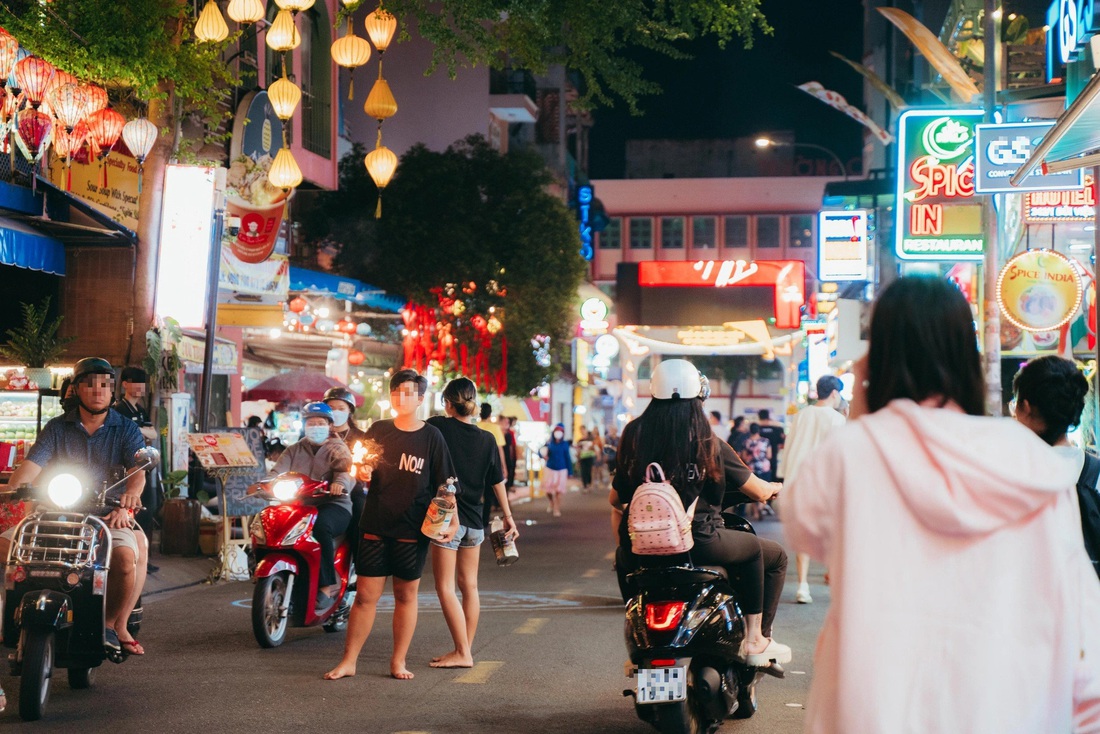 Hai đứa trẻ đứng ra giữa đường "phun lửa" mặc kệ xe cộ qua lại trên phố Bùi Viện - Ảnh: THANH HIỆP