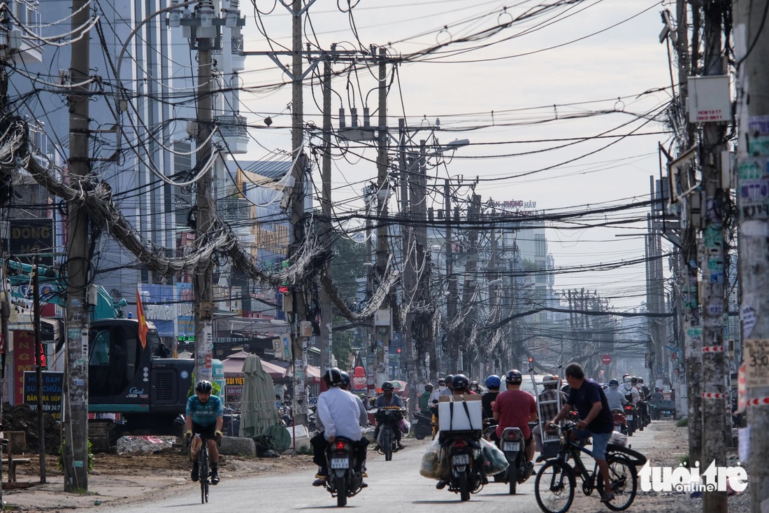 Trong khi đó, cột điện, dây điện vẫn còn chằng chịt - Ảnh: PHƯƠNG NHI 