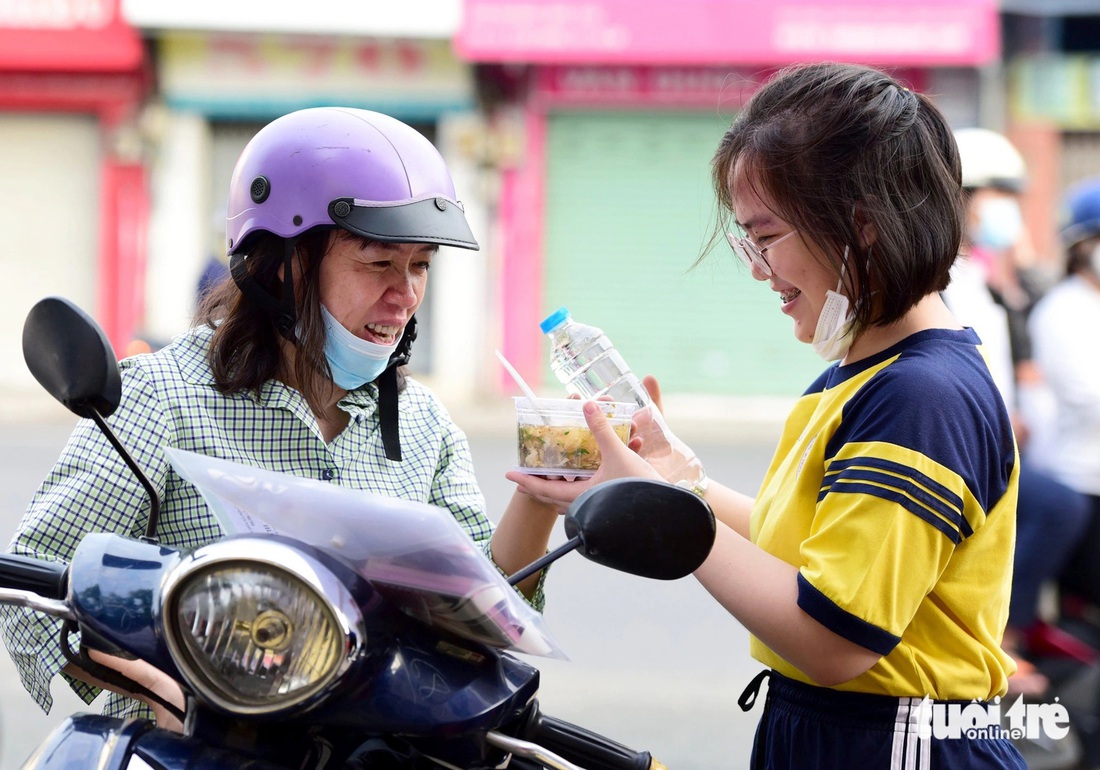 Phụ huynh lo bữa sáng cho con trước khi vào thi môn văn tại điểm thi THPT Nguyễn Thượng Hiền (quận Tân Bình) - Ảnh: DUYÊN PHAN