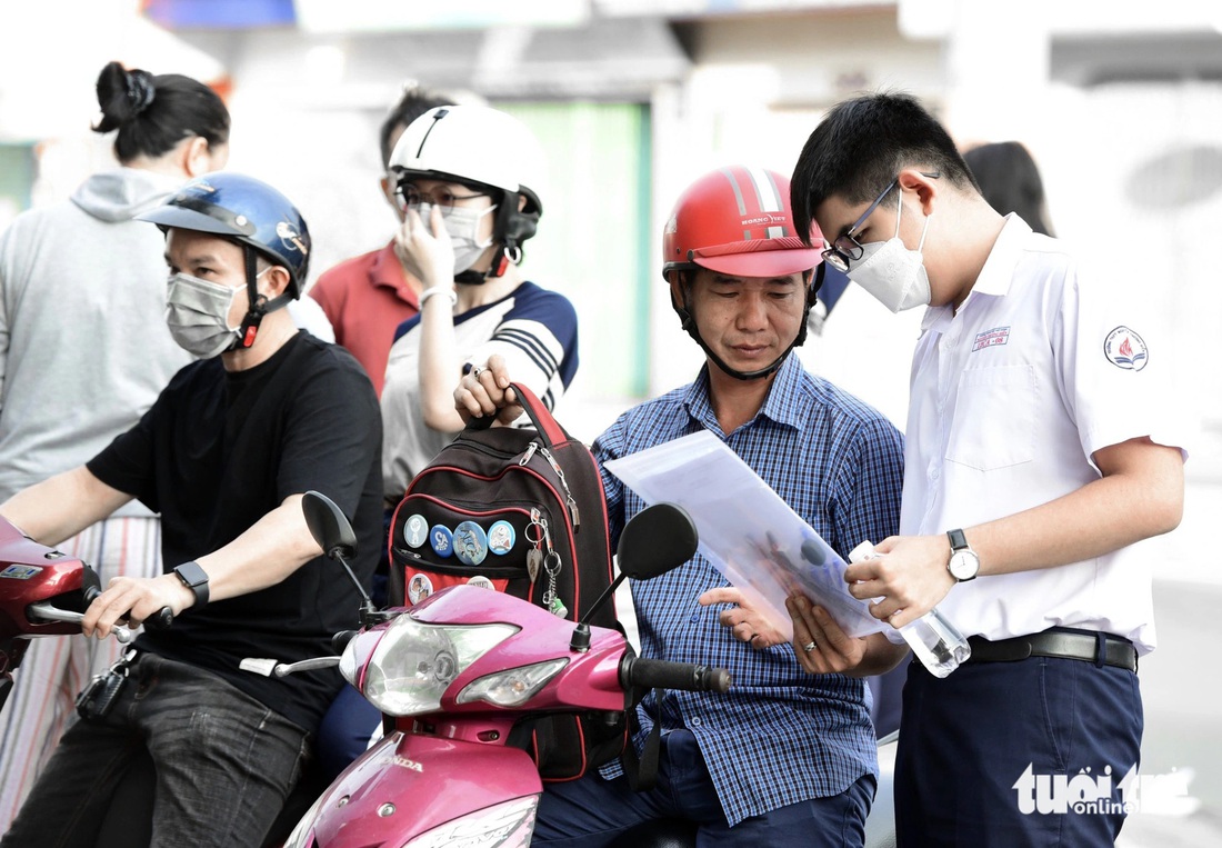 Cùng con kiểm tra lại giấy tờ trước khi vào phòng thi tại điểm thi THPT Nguyễn Thượng Hiền (quận Tân Bình) - Ảnh: DUYÊN PHAN