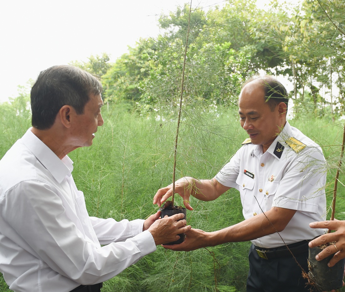 Đại tá Nguyễn Trung Quảng - phó chủ nhiệm hậu cần kỹ thuật hải quân Vùng 4 - chia sẻ kinh nghiệm làm bầu ươm cho cây khỏe khi đưa lên tàu ra Trường Sa với ông Khoa