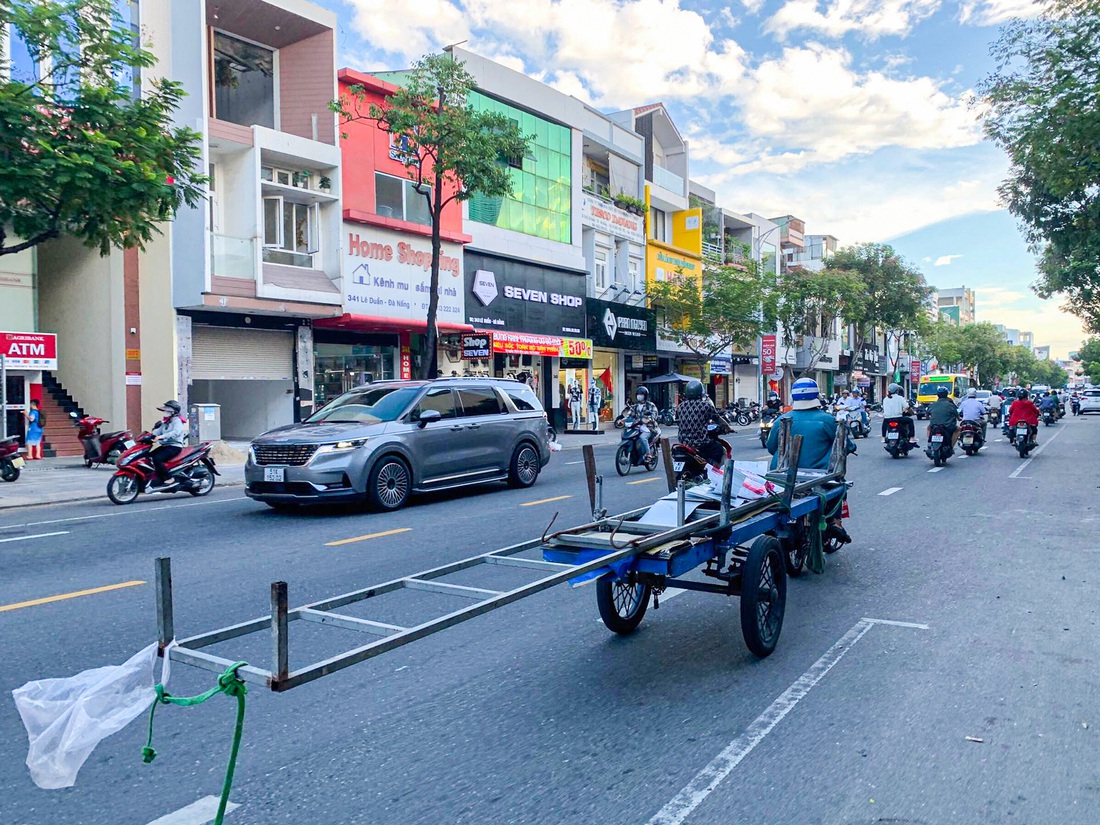 Một chiếc xe ba gác chở đoạn sắt dài chạy bon bon trên đường Lê Duẩn (quận Thanh Khê, TP Đà Nẵng) - Ảnh: THANH NGUYÊN