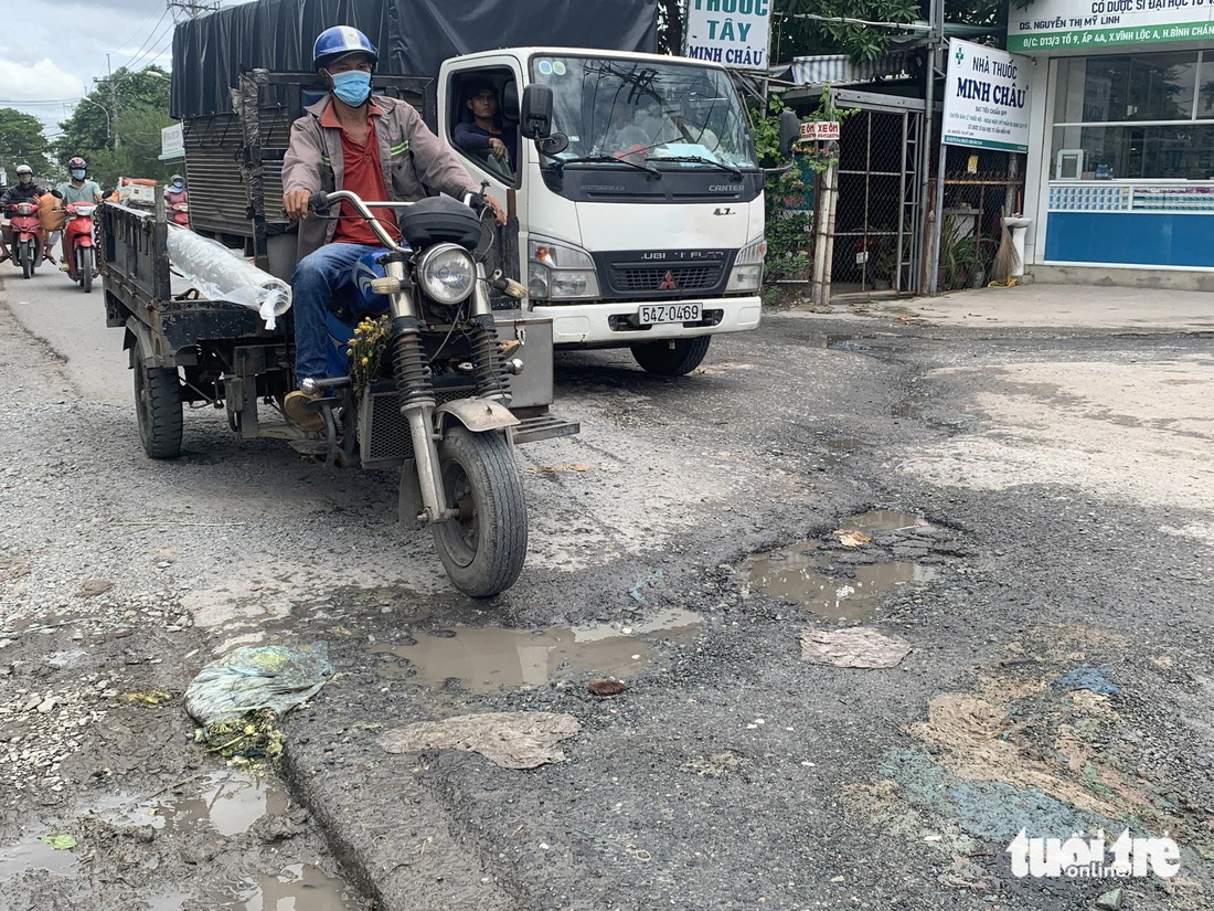 Các phương tiện đi trên đường Phạm Văn Sáng (xã Vĩnh Lộc A, huyện Bình Chánh) đều phải giữ tốc độ ở mức tối thiểu để tránh gây tai nạn giao thông - Ảnh: KSOR QUÝ