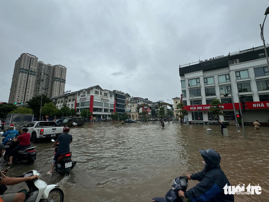 Nước bủa vây lối vào khu đô thị Nam An Khánh - Ảnh: THÀNH CHUNG