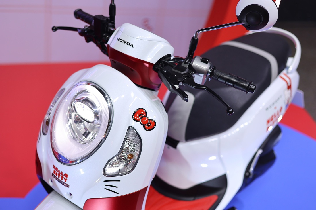 Honda Scoopy thêm bản Hello Kitty hút phái nữ, giá dễ trên 70 triệu nếu về Việt Nam- Ảnh 3. Chiếc nơ dễ thương còn được dập nổi 3D ở phía trước, phía trên đèn xi nhan trái, kèm logo kỷ niệm 50 năm Hello Kitty ra đời. Tem đánh số thứ tự sản xuất nằm ở phía sau cổ xe, nâng tầm tính chất "giới hạn" cho dân chơi xe