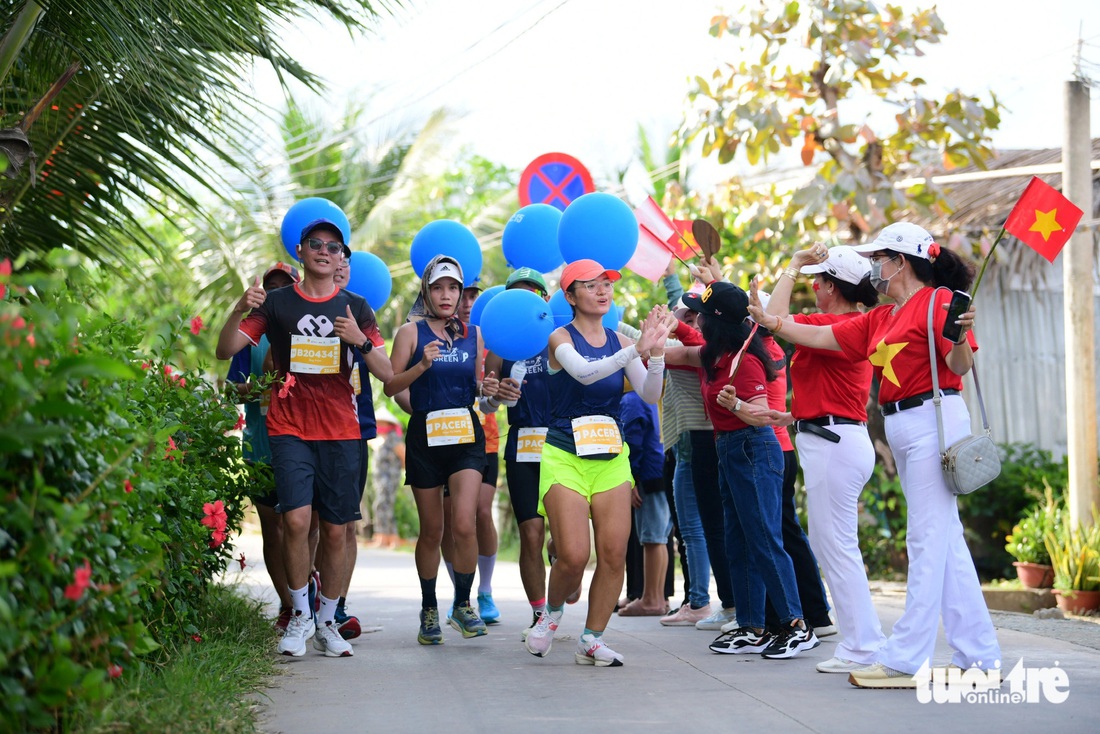 Người dân tưới nước, làm mát cho các runner ở GreenUP Marathon - Long An Half Marathon 2024 - Ảnh 2.