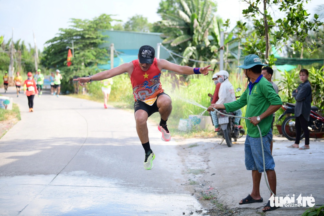 Người dân tưới nước, làm mát cho các runner ở GreenUP Marathon - Long An Half Marathon 2024- Ảnh 4.