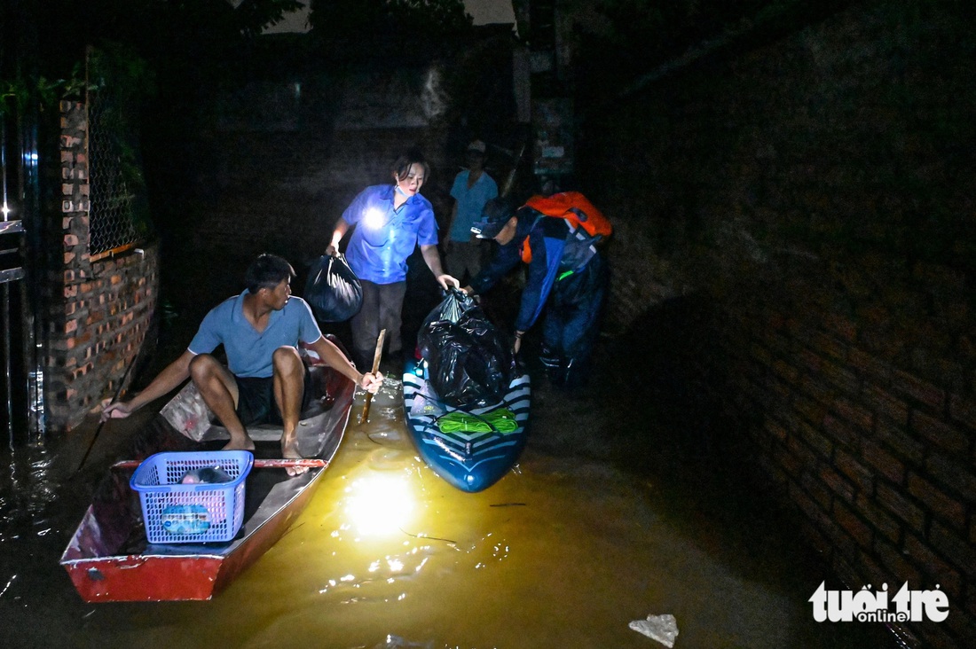 Nhóm bạn trẻ chèo SUP xuyên đêm 'giải cứu' nhiều người kẹt ở khu dân cư sát sông Hồng - Ảnh 1.