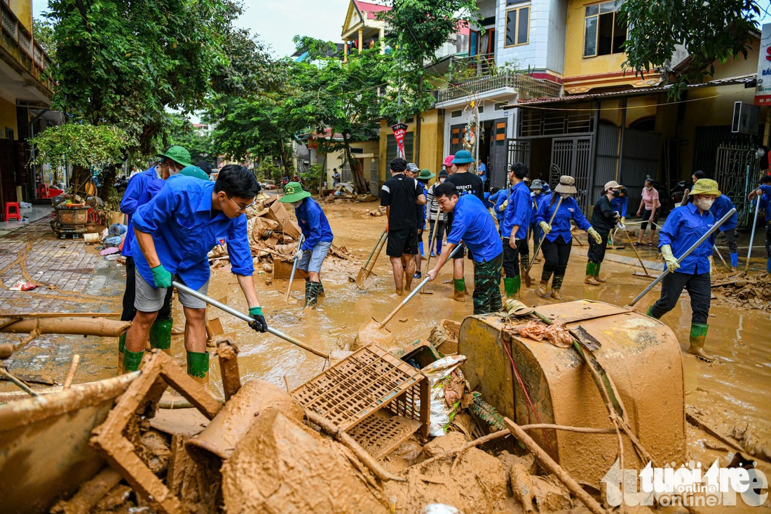 Áo xanh tỏa khắp thành phố, giúp bà con vùng lũ Yên Bái cào bùn, dọn rác thải - Ảnh 1.