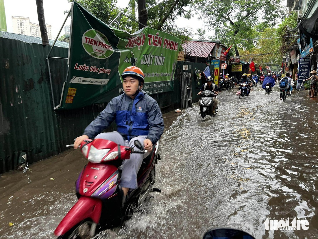 Sáng đầu tuần, đường phố Hà Nội lại ngập sau mưa lớn, có đoạn ngập dài 2km - Ảnh 11.