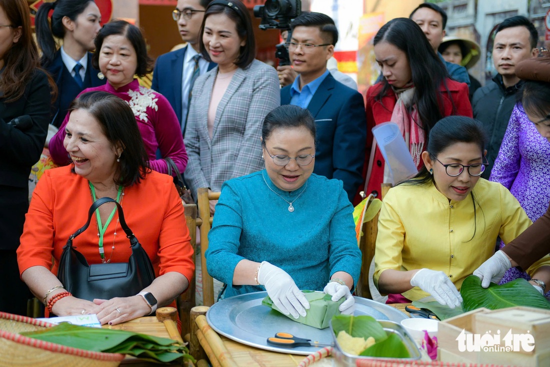 Phu nhân Ngô Phương Ly trổ tài 'vào bếp', gói bánh chưng cùng các nữ đại sứ - Ảnh 2.