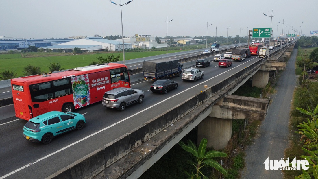 Xe đò tranh thủ quay đầu rước khách từ thành phố về quê khiến cao tốc ùn ứ   - Ảnh 1.