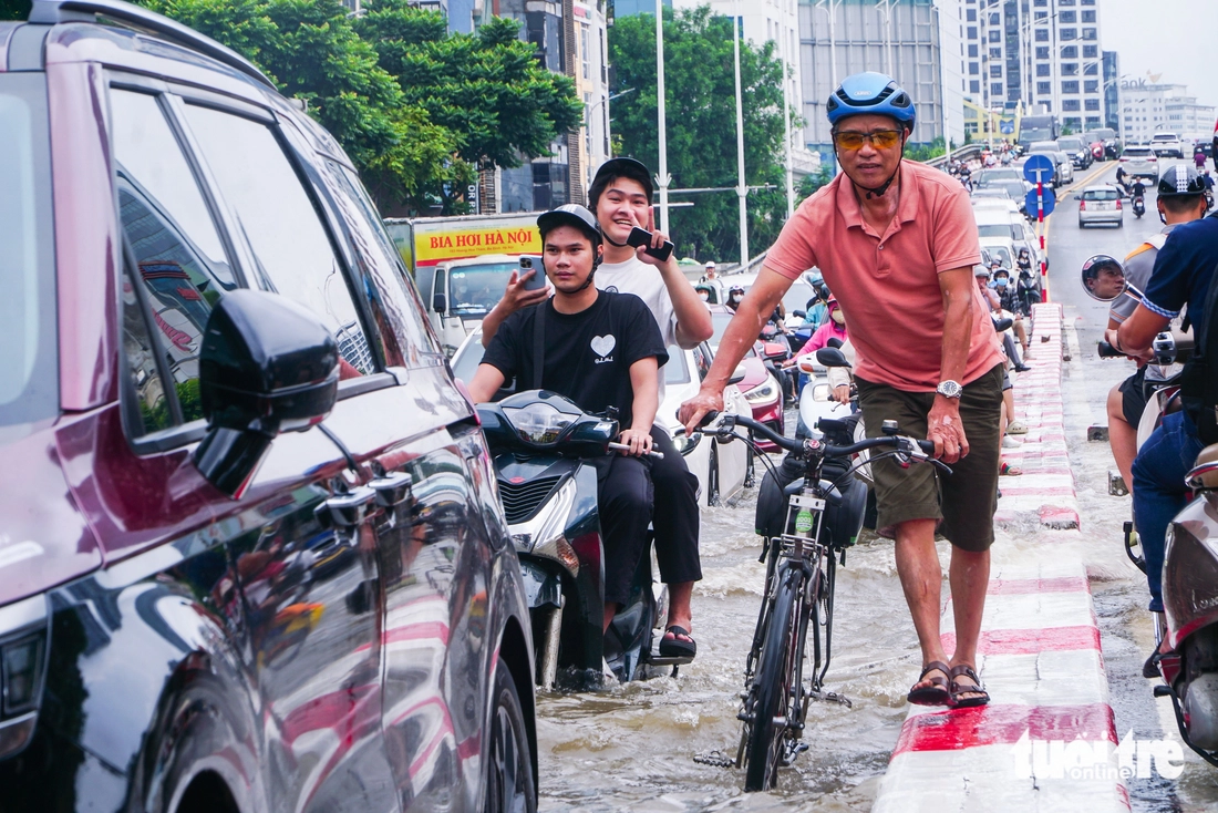 Hà Nội vẫn ngập khắp nơi, thợ sửa xe 'cắm chốt' ngay tại điểm ngập để sửa xe chết máy - Ảnh 1.