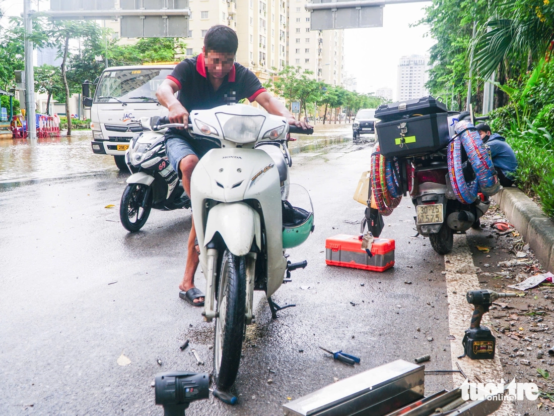 Hà Nội vẫn ngập khắp nơi, thợ sửa xe 'cắm chốt' ngay tại điểm ngập để sửa xe chết máy - Ảnh 15.