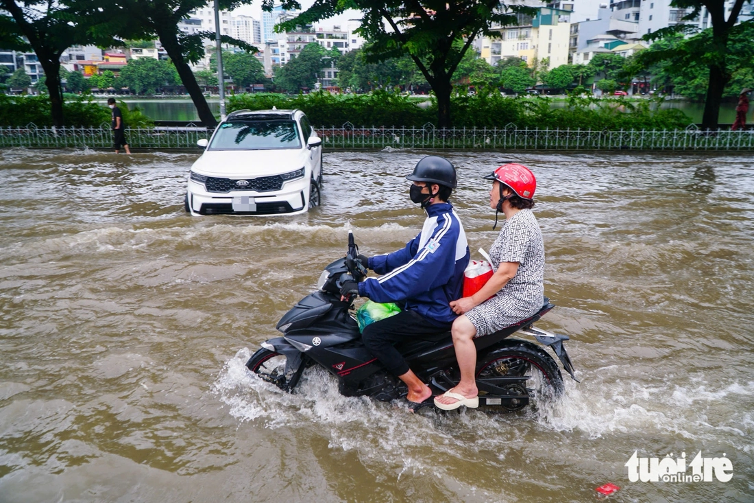 Hà Nội vẫn ngập khắp nơi, thợ sửa xe 'cắm chốt' ngay tại điểm ngập để sửa xe chết máy - Ảnh 6.