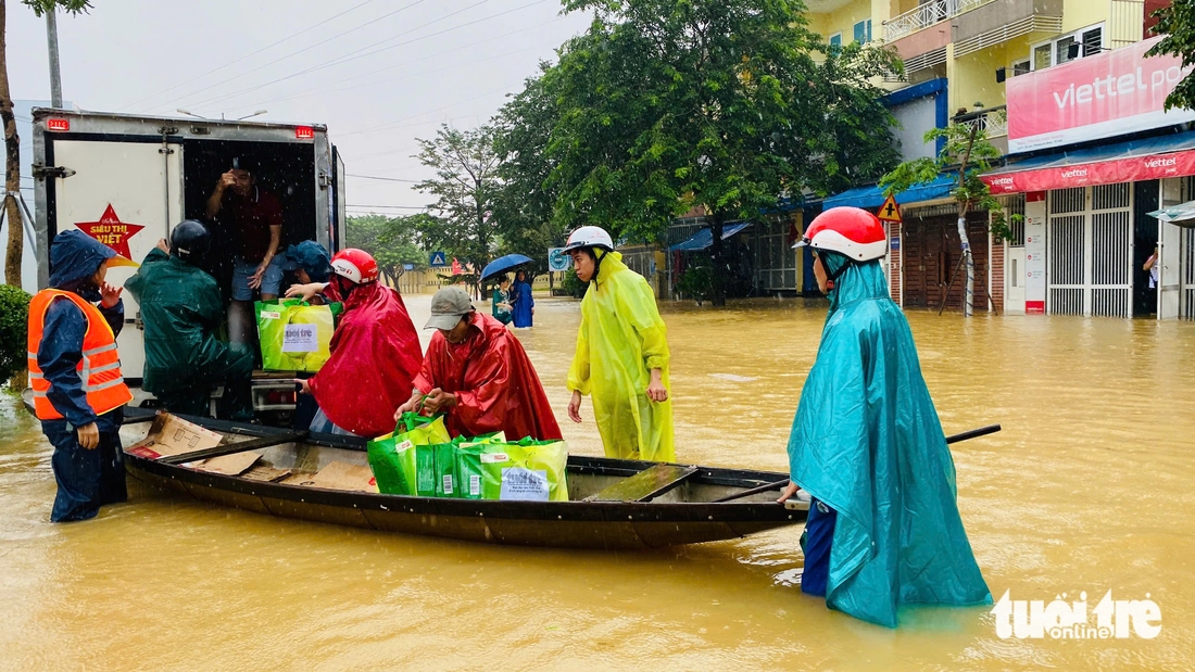 Hàng trăm suất quà cứu trợ của báo Tuổi Trẻ băng nước lũ đến với bà con vùng ngập sâu - Ảnh 3.