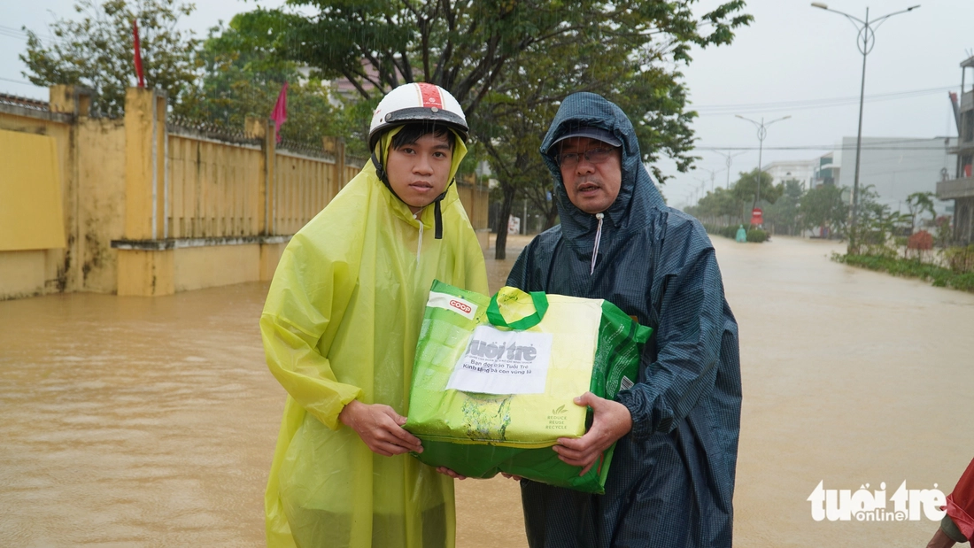 Hàng trăm suất quà cứu trợ của báo Tuổi Trẻ băng nước lũ đến với bà con vùng ngập sâu - Ảnh 6.