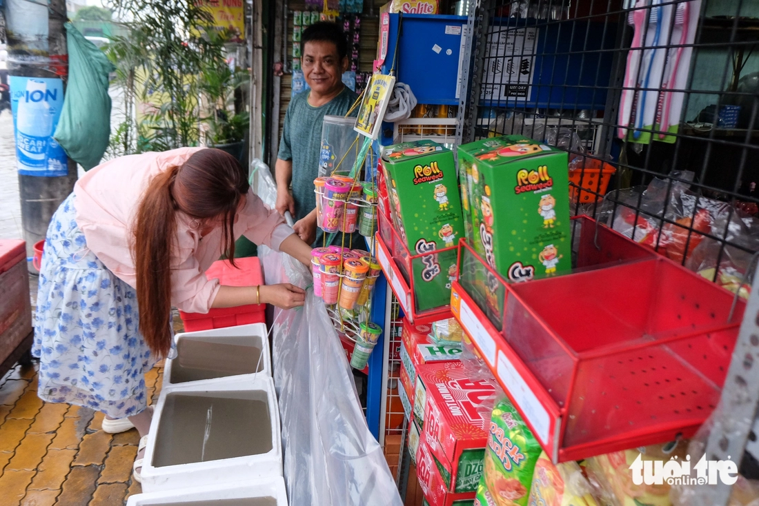 Quốc lộ 50 ‘chìm’ trong triều cường, người dân chung tay căng bạt, đắp cát ngăn nước- Ảnh 2. Đường Văn Tiến Dũng ‘chìm’ trong triều cường, người dân chung tay căng bạt, đắp cát ngăn nước - Ảnh 2.