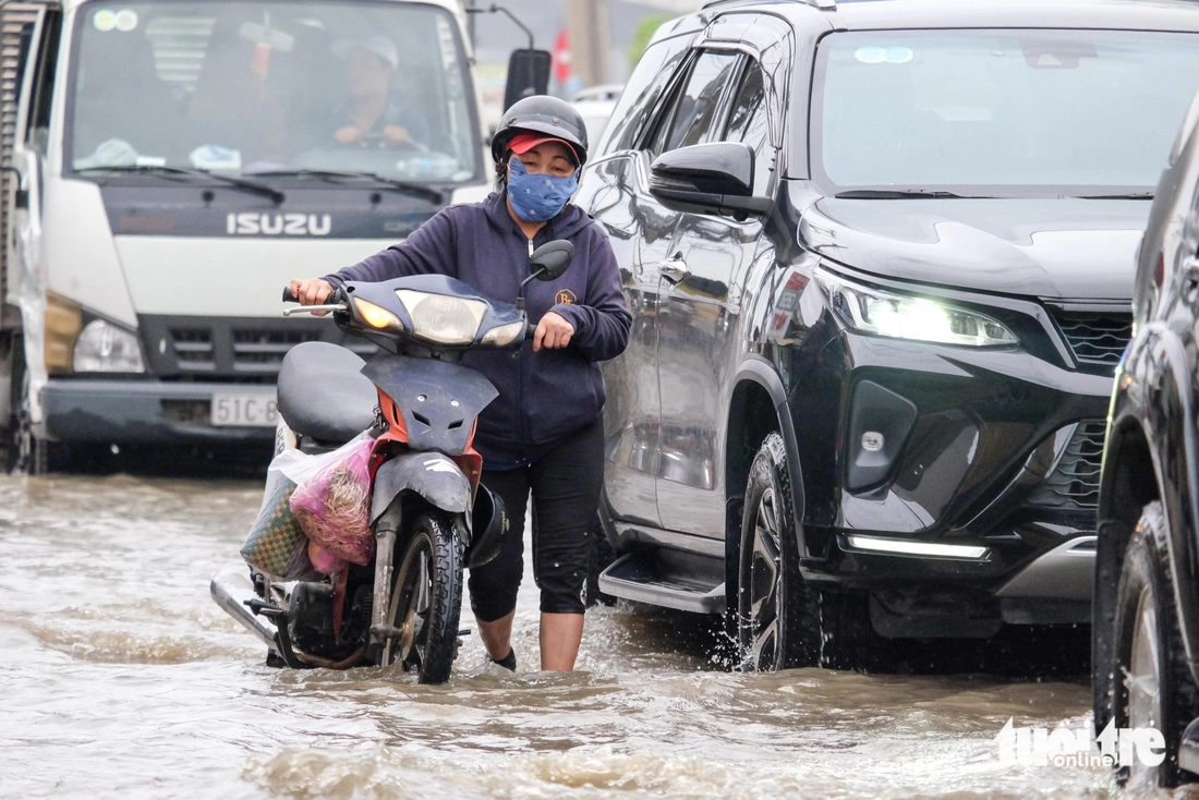 Quốc lộ 50 ‘chìm’ trong triều cường, người dân chung tay căng bạt, đắp cát ngăn nước- Ảnh 7. triều cường - Ảnh 7.