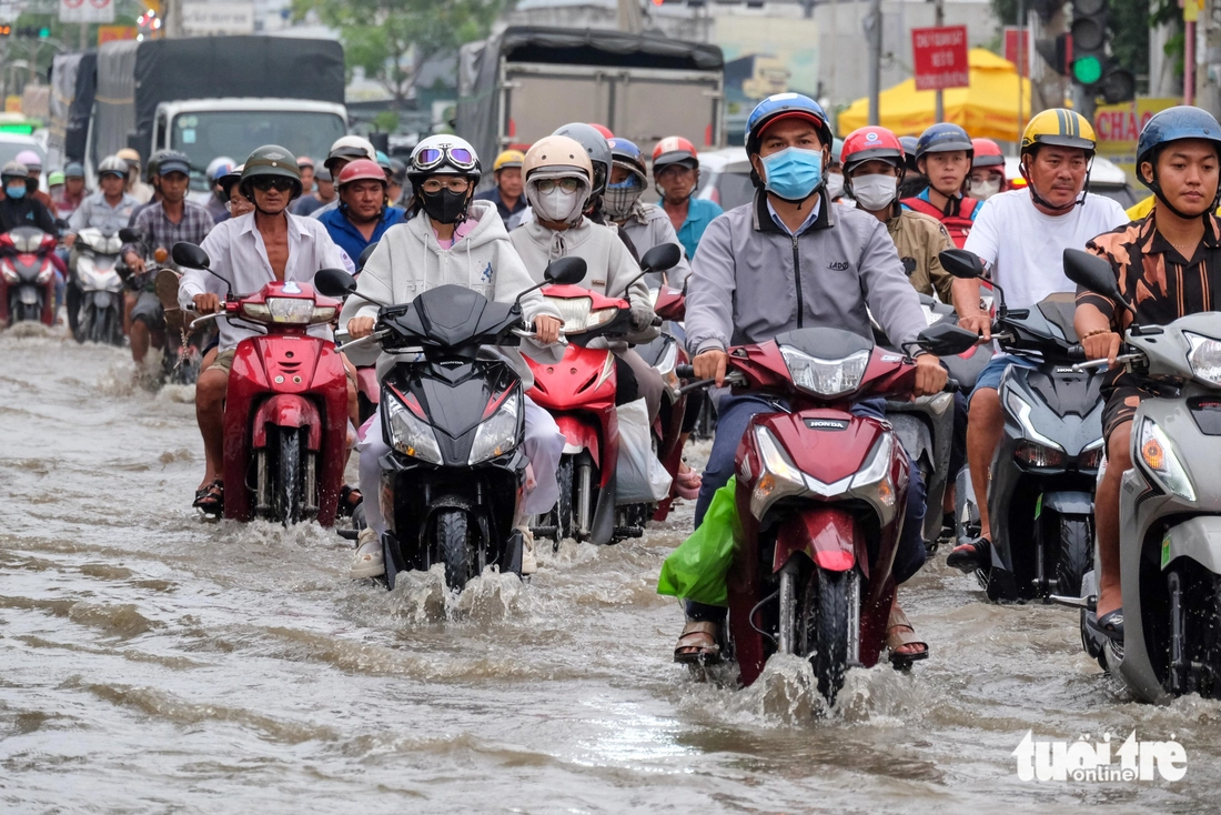Quốc lộ 50 ‘chìm’ trong triều cường, người dân chung tay căng bạt, đắp cát ngăn nước- Ảnh 8. triều cường - Ảnh 8.